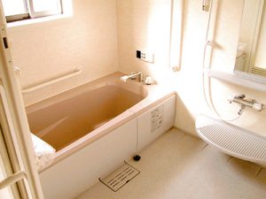 介護施設の浴室。広い浴槽と手すり、清潔な設備が整備されています。